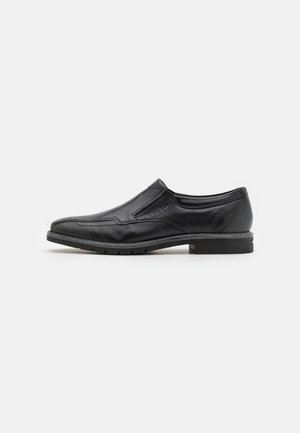 Chaussure noire en cuir à enfiler, présentant une finition lisse, un bout rond, des détails de couture subtils et un petit talon empilé.