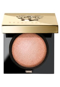Bobbi Brown Highlighter-Compact mit einem goldfarbenen, reflektierenden Deckel, der ein strukturiertes, roségoldfarbenes Puder im Inneren zeigt, auf einem schwarzen Grund.