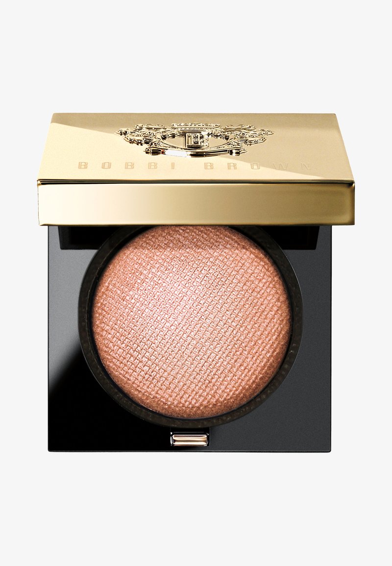Bobbi Brown highlighter compact met een goud reflecterende deksel, met een textuurpoeder in roségoud binnenin, tegen een zwarte basis.