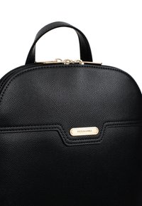 Zaino in pelle nera texturizzata con parte superiore curvata, hardware della zip dorata e una placca con logo dorato, caratterizzato da un design strutturato e dettagli lisci.