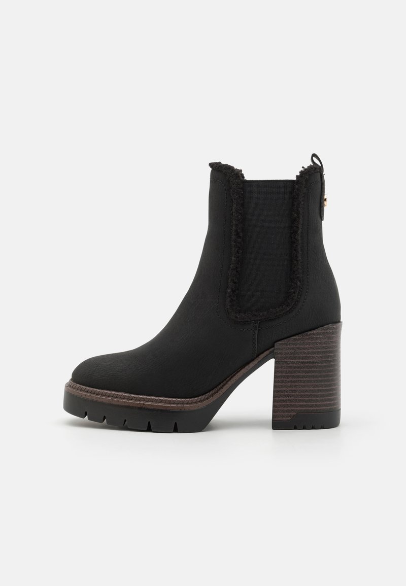 Botine negre până la gleznă cu o finisare texturată, panouri laterale elastice, un toc gros din lemn și margini destrămate pe partea superioară.