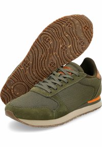 Sneaker in rete verde e suede con suola texturizzata marrone, allacciatura frontale e accento arancione sulla suola intermedia beige, mostrata da angolazioni laterali e inferiori.