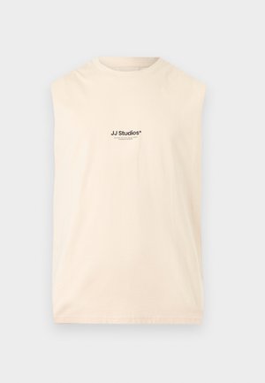 Top bej fără mâneci, cu guler rotund și mic logo negru „JJ Studios”, centrat în față.