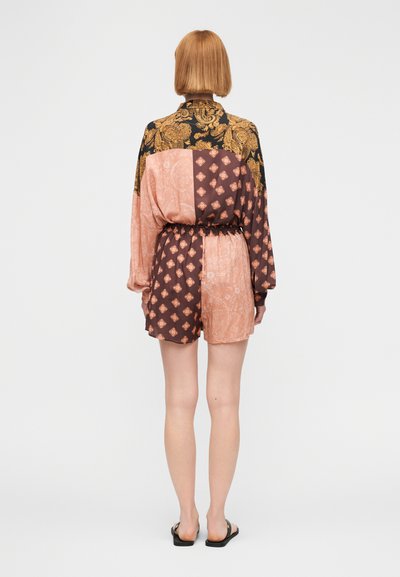 Ολόσωμη φόρμα με κοντά μανίκια και συνδυασμό σχεδίων σε μαύρο, ροζ και καφέ. Διαθέτει ελαστική μέση και άνετη εφαρμογή.