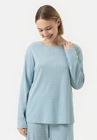 Haut à manches longues bleu clair avec un motif en diamant texturé, présentant un col bateau et une coupe décontractée. Tissu doux avec une texture lisse.