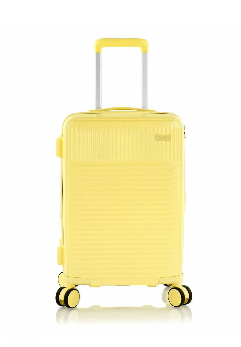 Valigia rigida gialla con design a coste, manico retrattile, quattro ruote doppie e chiusura a zip. Texture liscia e forma compatta.