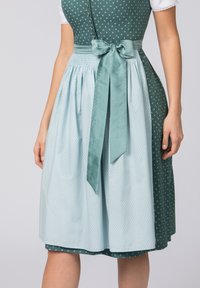 Green and light blue dirndl dress, featuring polka dots, a cinched waist with a satin bow, and a contrasting patterned bodice.