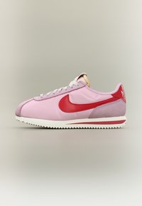 Nike-sneakers i rosa och rött, med en slät överdel, mockadetaljer, rund tå och en mönstrad gummisula.