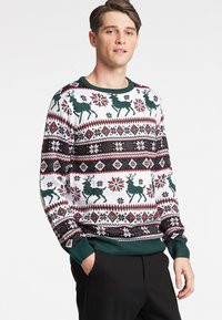 Suéter de Natal de malha com base branca, rena verde, flocos de neve vermelhos e padrões geométricos. Punhos e bainha canelados em verde escuro.