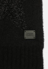 Sciarpa nera in maglia con una texture soffice, caratterizzata da un motivo di stelle nere lucide e un'etichetta rettangolare in pelle nera con la scritta "ALLSAINTS".