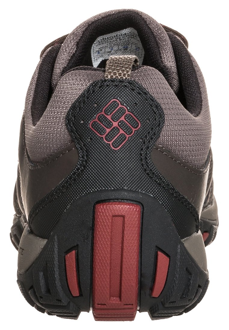 Czarno-szary sportowy but z teksturowaną syntetyczną cholewką, wyściełanym kołnierzem oraz czerwoną i czarną naszywką na pięcie z logo.