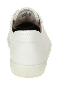 Sneaker bianco con tomaia in pelle liscia, forma arrotondata, colletto imbottito e suola in gomma testurizzata. L'interno mostra l'etichetta e i dettagli sulle taglie.