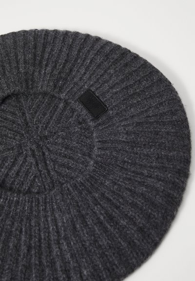 Donkergrijze gebreide beanie met ribbeltextuur, ronde vorm en een klein zwart labelaccent. Zacht en dik materiaal.