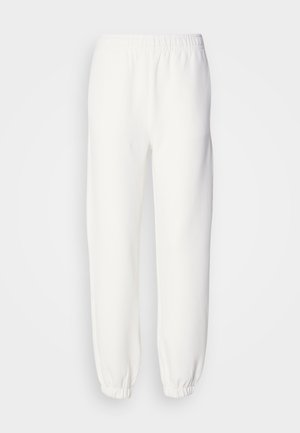 Pantaloni della tuta bianchi realizzati in morbido tessuto lavorato a maglia. La vita e i polsini elasticizzati offrono una vestibilità rilassata. Design minimalista, senza motivi o accenti visibili.