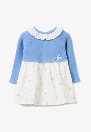 Niebieska dzianinowa sukienka dla niemowląt z długim rękawem, białą spódnicą w kwiaty, falbanianym kołnierzykiem i małą kokardką na piersi.