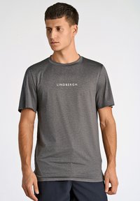 Szara krótko rękawowa koszulka sportowa wykonana z lekkiego materia�łu, z okrągłym dekoltem oraz poziomym teksturowanym wzorem z logo "LINDBERGH".