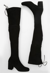 Botas de ante negras hasta la rodilla con tacón cuadrado. Cuentan con una textura suave y lazos ajustables en la parte superior para un ajuste personalizado.