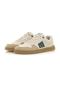Sneaker beige con una combinazione di materiali in pelle e suede, caratterizzata da un logo verde, lacci rotondi e una suola in gomma testurizzata.