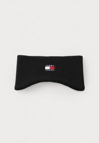 Bandeau en tricot noir au design arrondi, comportant une petite étiquette de logo Tommy Jeans en rouge, blanc et bleu. Texture douce, sans motifs visibles.