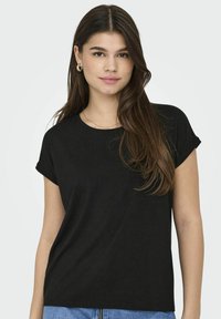 T-shirt nera a maniche corte con scollo rotondo e risvolti, realizzata in tessuto morbido con una leggera trama. Vestibilità casual, senza fantasie.
