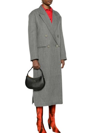 Cappotto grigio doppiopetto con rever pronunciati e due bottoni, abbinato a stivali arancioni fino al ginocchio e una piccola borsa nera.