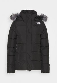 Veste d'hiver noire isolée avec capuche et bordure en fausse fourrure grise, fermeture éclair à l'avant, poches latérales, et logo The North Face sur la poitrine.