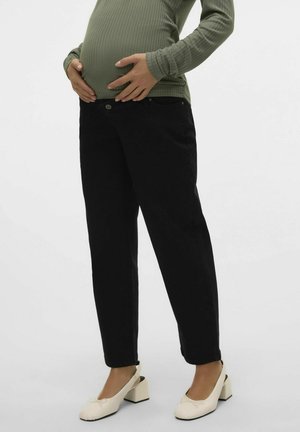 Mustat äitiysfarkut rennolla istuvuudella, jossa on napp closure ja taskut. Yhdistetty vihreään ribattuun pitkähiharaiseen puseroon ja kermaisiin kenkiin.