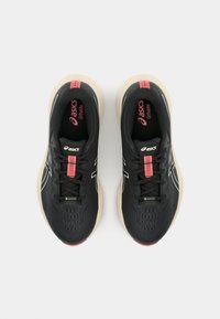 Baskets de sport noires avec une tige en mesh léger, des superpositions synthétiques, des accents roses et une semelle rembourrée. Comprend des lacets et une marque.