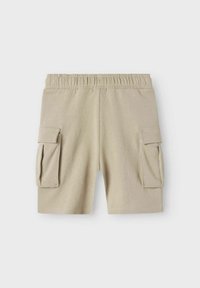 Beige cargo shorts lavet af blødt stof, med elastisk talje og to sidelommer med klaplukninger.
