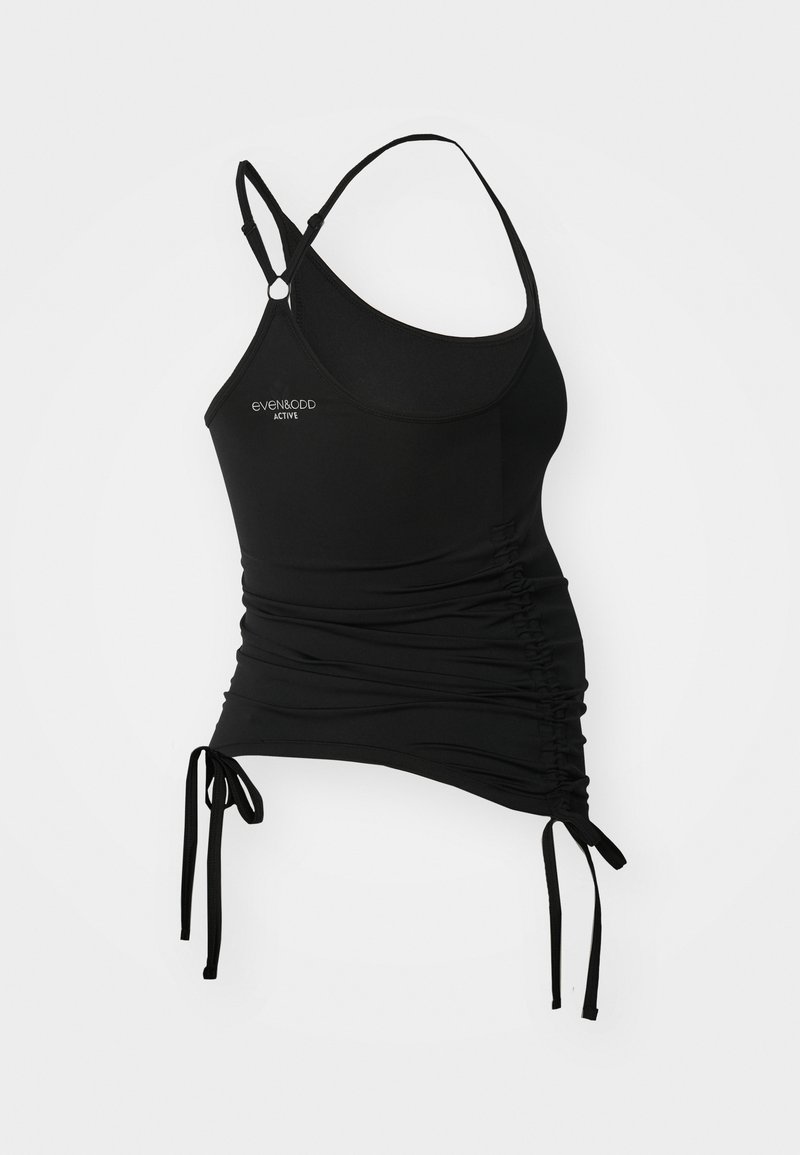 Top activo negro con tirantes finos, fruncido en los lados y lazos ajustables en el dobladillo. Fabricado con una tela suave y elástica.
