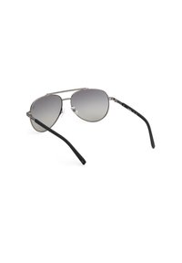 Gafas de sol con montura de metal, lentes degradados y brazos curvados en negro. Presentan un diseño de doble puente y una sutil marca en las patillas.