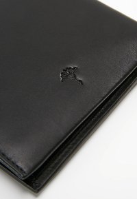 Černá kožená peněženka s hladkým povrchem. Obsahuje vytlačený emblém v rohu a prošívané okraje pro odolnost. Kompaktní design.