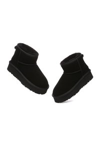 Black ankle boots made of suede, featuring a plush lining, rounded toe, and rubber outsole. The design includes a stitched seam and a low heel.