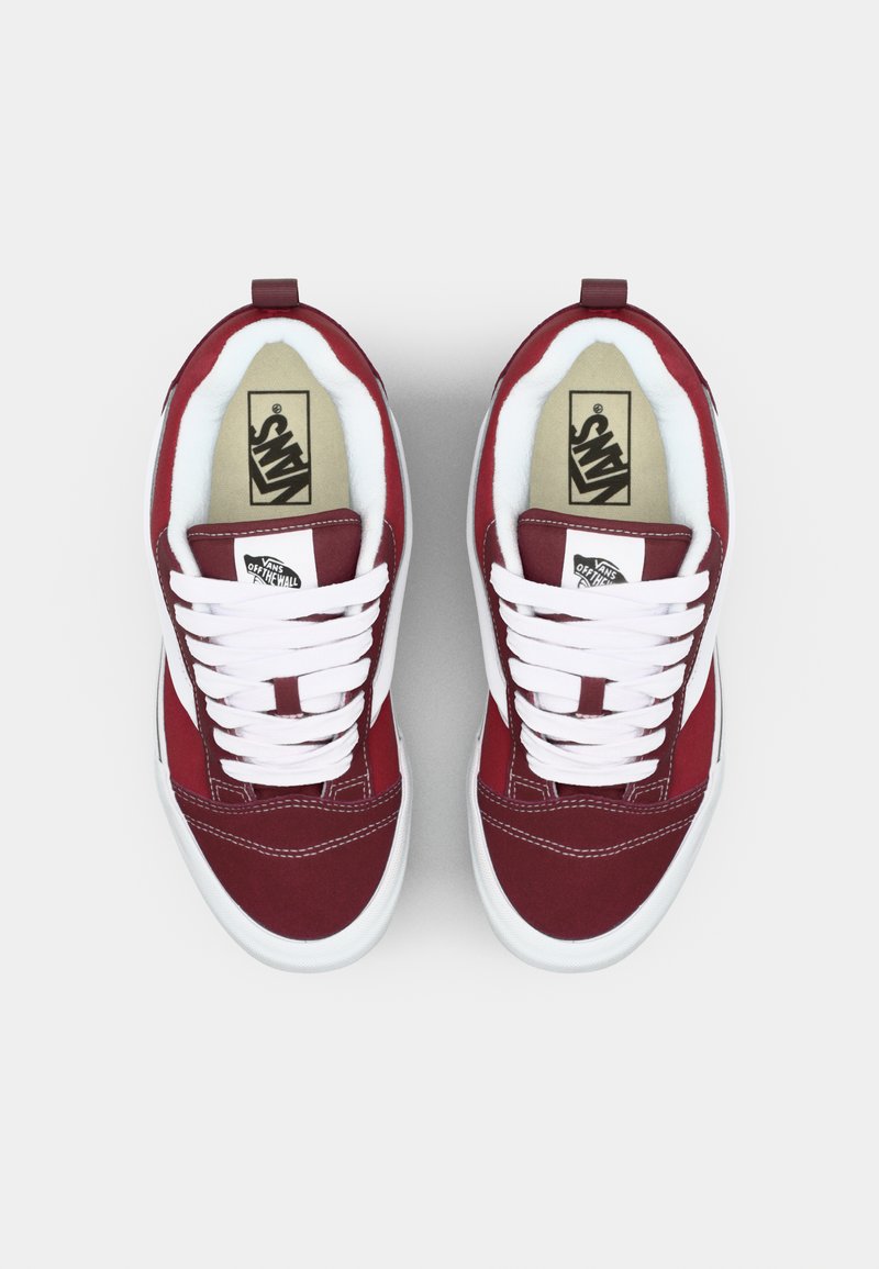 Rode canvas sneakers met witte veters en zijstrepen, voorzien van een gewatteerde kraag en een gestructureerde rubbersole, gemarkeerd met het Vans-logo.