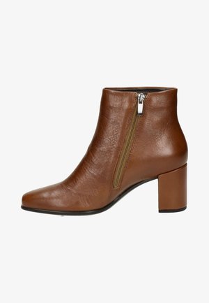 Botín de cuero marrón hasta el tobillo con punta afilada, detalle de cremallera lateral y tacón cuadrado, con una textura suave y un diseño minimalista.