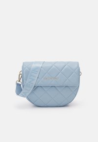 Ljusblå vadderad handväska med rundad form, guldfärgade detaljer och en ton-i-ton logotyprem. Texturerad yta med diamantmönstrade accenter.