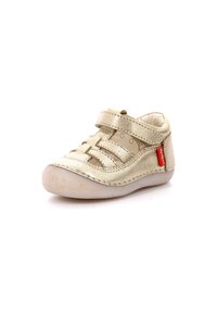 Scarpa per bambini oro metallizzato con suola bianca flessibile, lati aperti e fascia con chiusura a velcro per una vestibilità regolabile. Presenta dettagli cuciti.