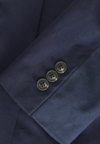 Sleev odijela tamnoplave boje s glatkom teksturom, uz tri tamne gumbe i fine šavove na manžetama.