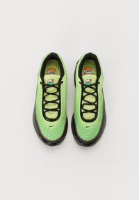 Green mesh sneakers with black accents, featuring a streamlined shape, lace-up design, and visible air cushioning in the sole.