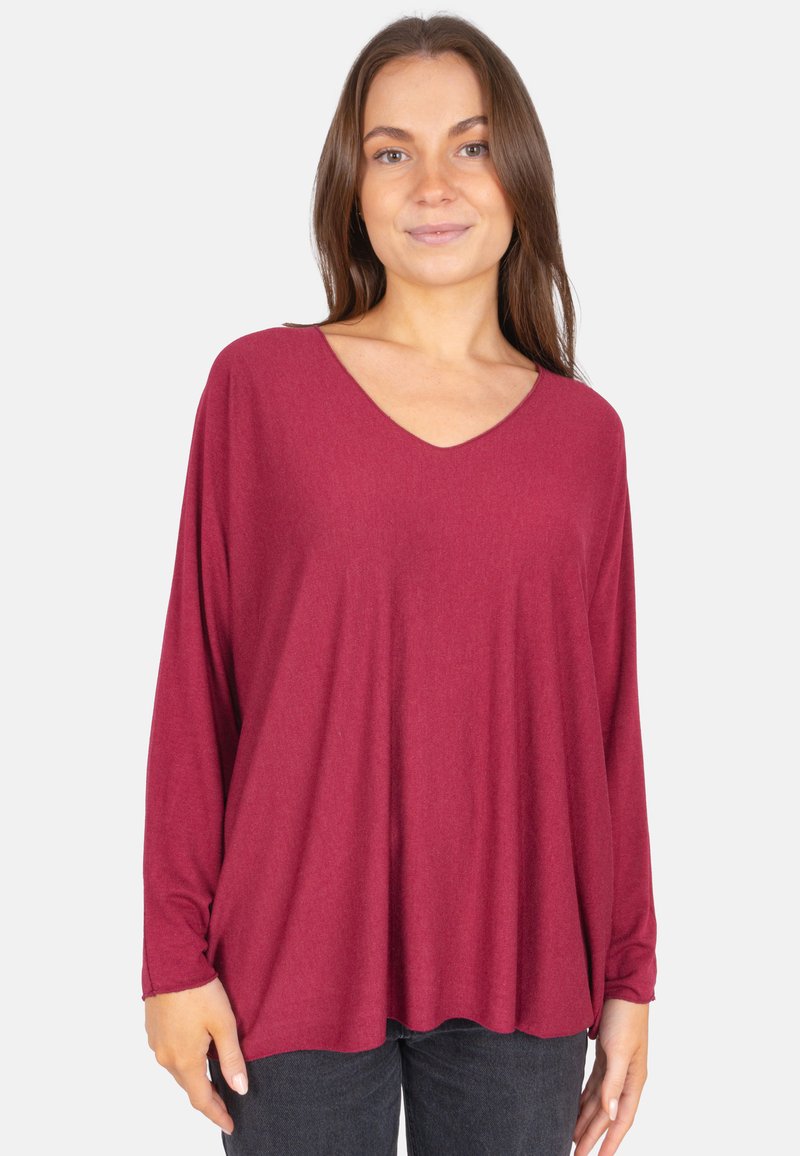 Haut à manches longues bordeaux avec un décolleté en V, fabriqué dans un tissu doux et texturé ; coupe ample avec un ourlet inférieur arrondi.