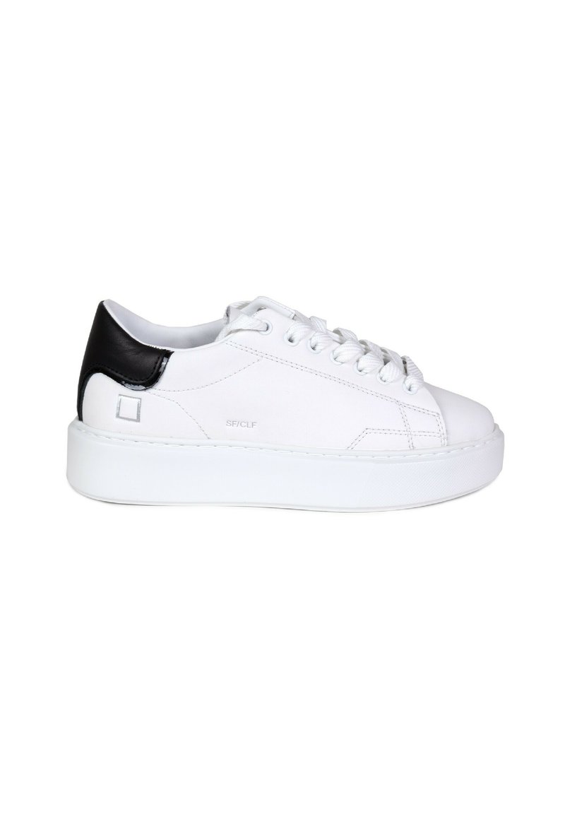 Baskets blanches avec un talon en cuir noir, bout rond et semelle plate ; elles présentent une texture lisse et des détails de couture discrets.