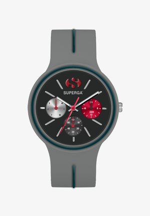 Pilkas silikono laikrodis su juodu ciferblatu, trimis subciferblatais raudona, balta ir juoda spalvomis bei sidabriniais valandų ir minučių rodyklėmis. Pabrėžia šviesiai mėlynus akcentus.