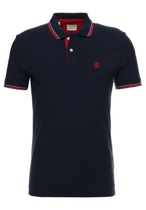Navy blauw poloshirt met korte mouwen met rood-wit gestreepte kraag en mouwen, twee witte knopen en een klein rood schildje op de borst.