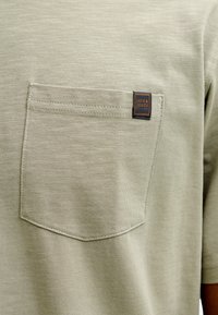 Φωτεινό πράσινο μπλουζάκι από υφασμάτινη ύφανση με ραμμένη τσέπη στο στήθος που φέρει μια μικρή μαύρη ετικέτα με την επιγραφή "Jack & Jones".