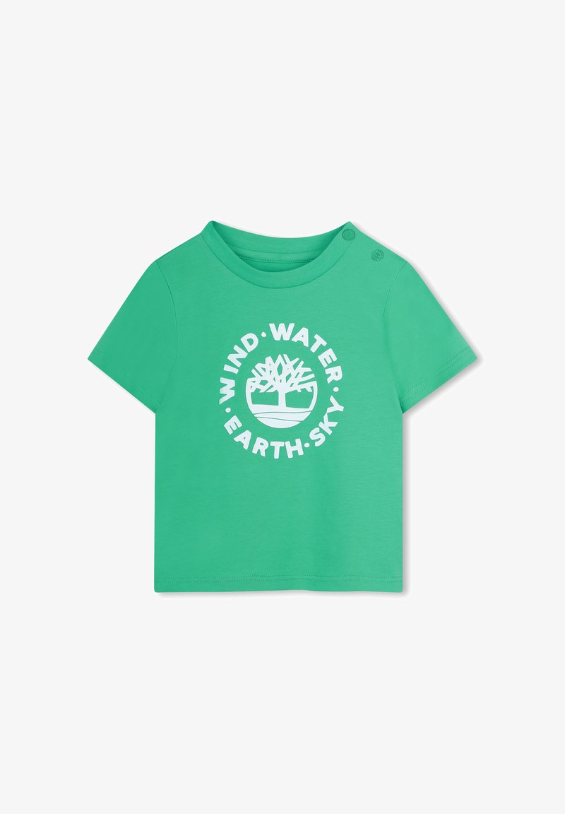 T-shirt vert à manches courtes en coton, avec un logo rond portant les mots "VENT • EAU • TERRE • CIEL" en blanc. Deux pressions sur l'épaule.