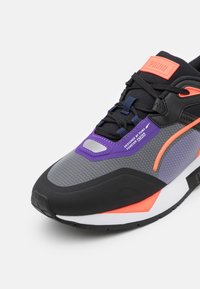 Czarno-szare sneakersy z teksturowaną cholewką, fioletowymi i neonowo-pomarańczowymi akcentami, wyposażone w wyściełany kołnierz oraz kontrastującą gumową podeszwę.