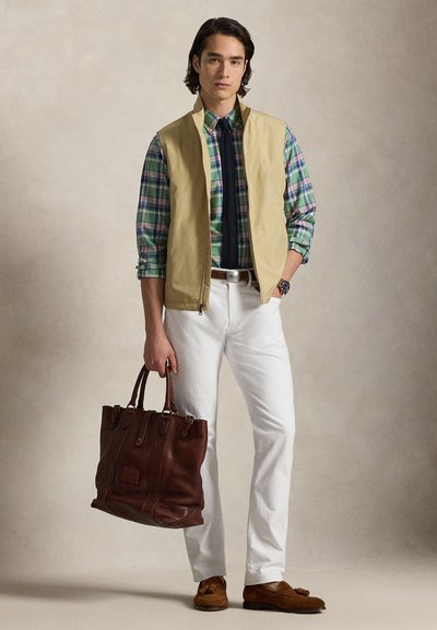 Μπεζ γιλέκο πάνω από μια καρό πουκάμισο σε μπλε, πράσινο και μπορντό, λευκό παντελόνι, καφέ δερμάτινη τσάντα και καφέ μοκασίνια. Καθημερινό, στρωμένο ντύσιμο.