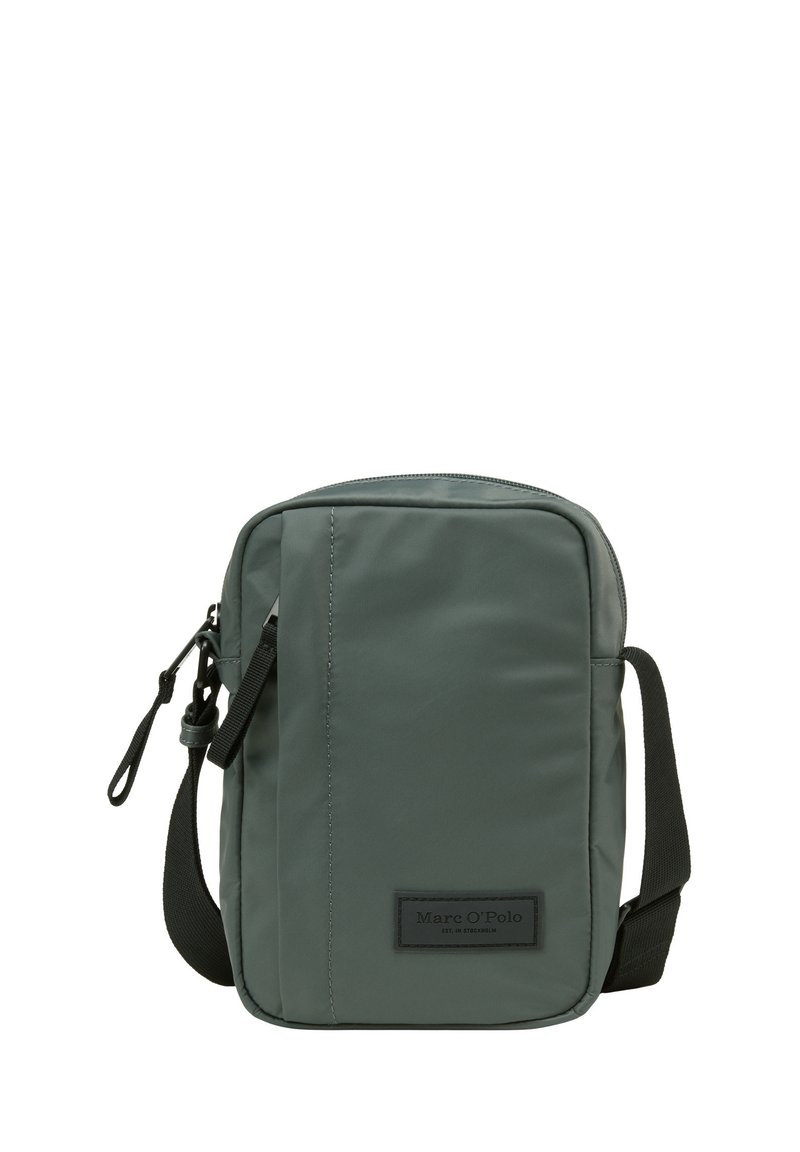 Borsa a tracolla compatta verde scuro con cinturino nero regolabile, chiusura con zip e un'etichetta del marchio cucita sul pannello frontale.