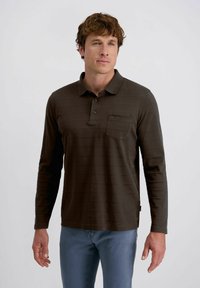 Langärmliges, dunkelbraunes Poloshirt mit strukturiertem, gestreiftem Design, zwei Knöpfen an der Knopfleiste und einer Brusttasche. Getragen mit hellblauen Jeans.