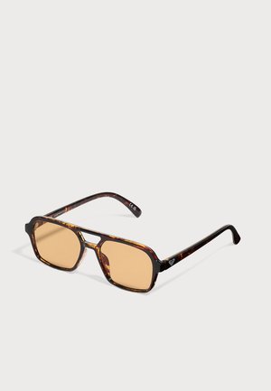 Gafas de sol rectangulares con montura carey, lentes tintadas en ámbar y doble puente sobre un fondo claro y liso.